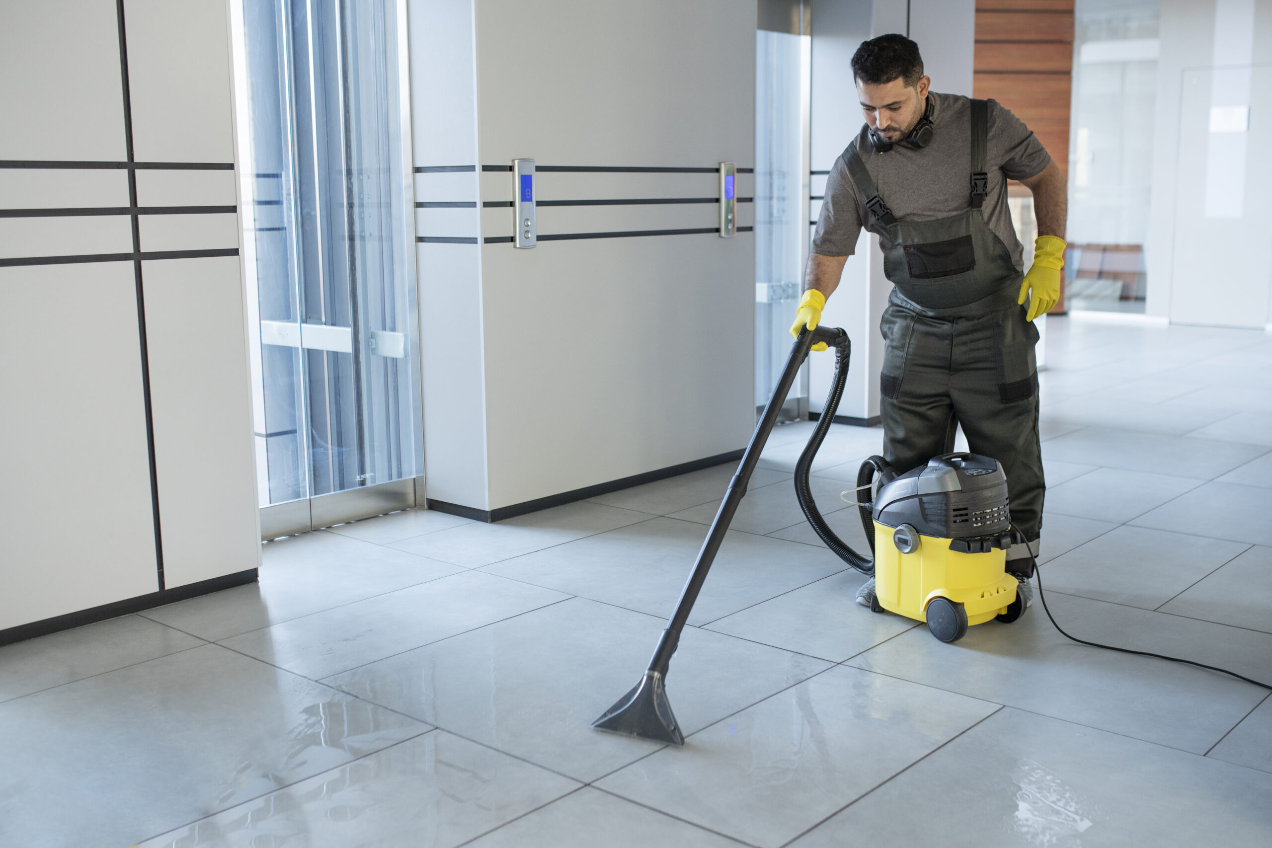 full shot man vacuuming office floor scaled